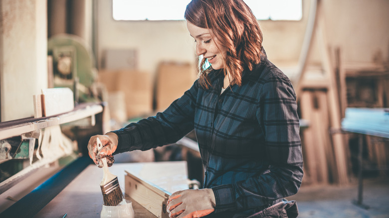 Woman applies wood stain