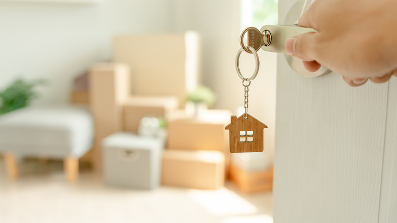 Man holding key house keychain in new apartment.