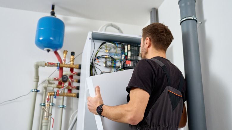 Man working on a heat pump in a basement