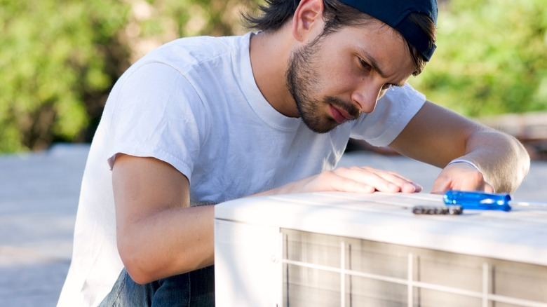 Man installing a heat pump outdoors