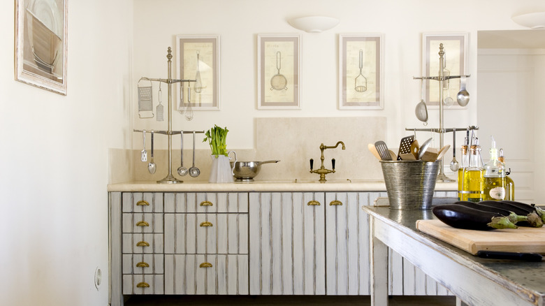 farmstyle kitchen with framed prints on the walls above the sink