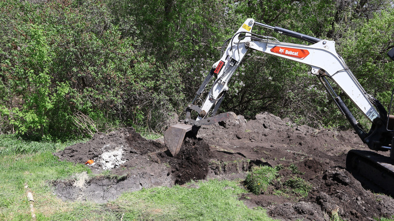 Septic tank installer digging up the yard for an installation