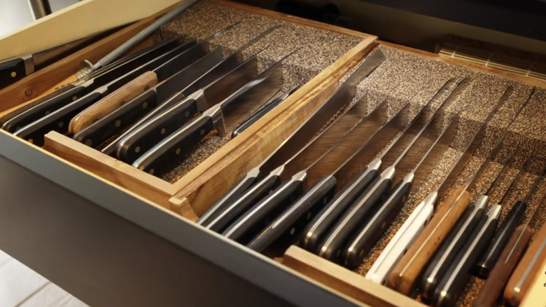Knives in drawer with corkboard