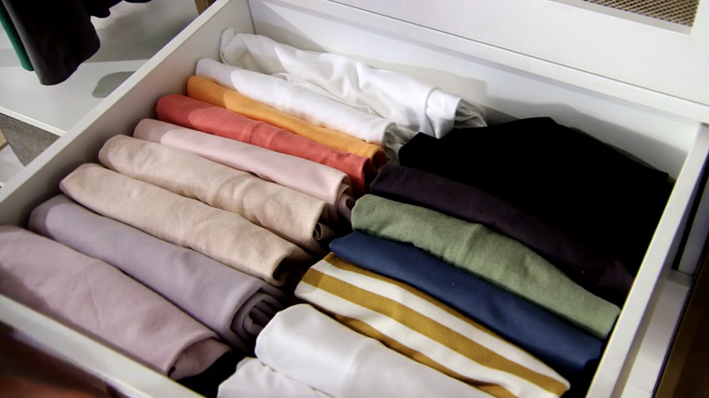 Shirts folded and lined up vertically in a drawer