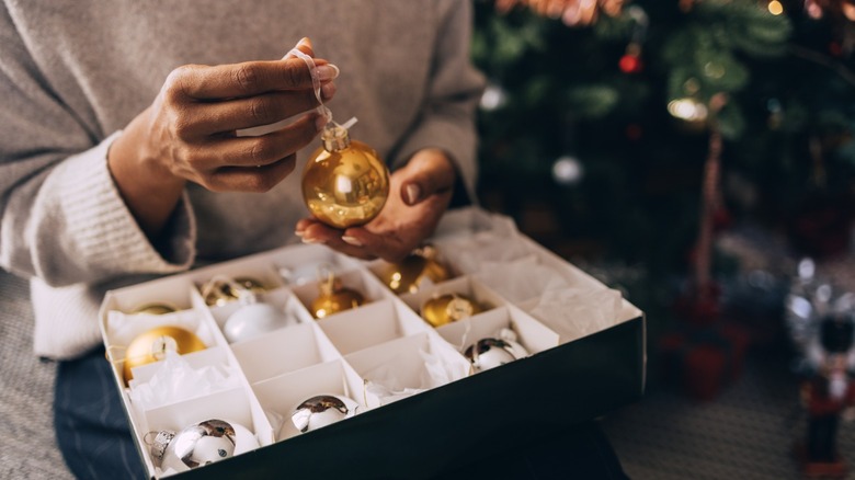 A woman holding ornaments in a box