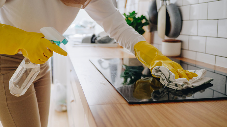 Person cleaning glass stove top