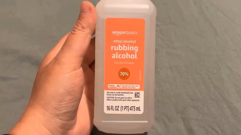 Person holding rubbing alcohol