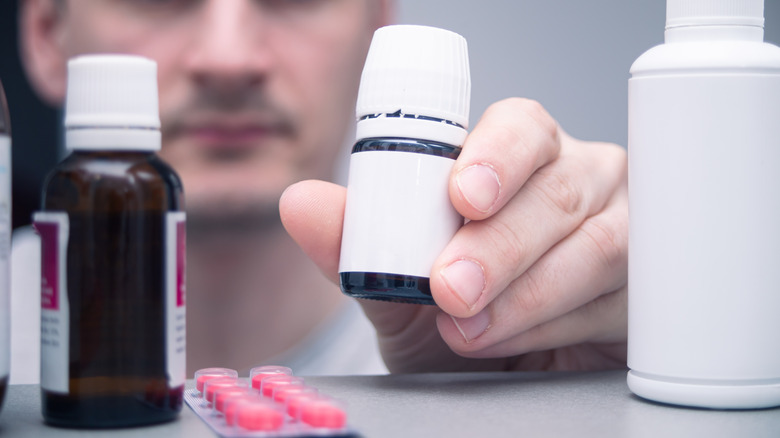 Man searching through a medicine cabinet
