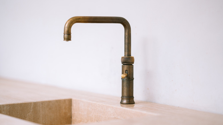Brass faucet over stone sink