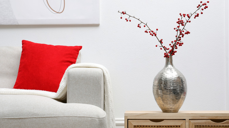 A liquid-like silver vase placed on a side console in a living room