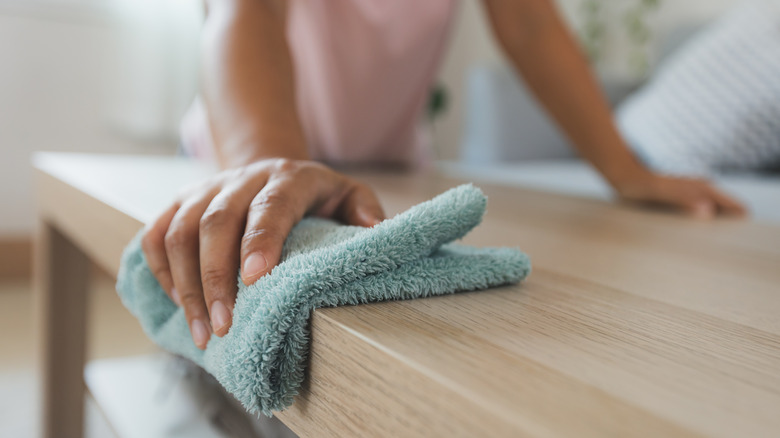 wiping coffee table with microfiber cloth