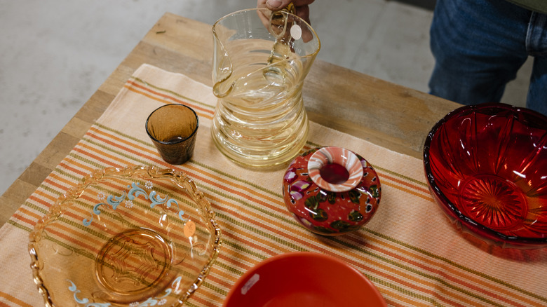 a person looking at colorful glass at a flea market