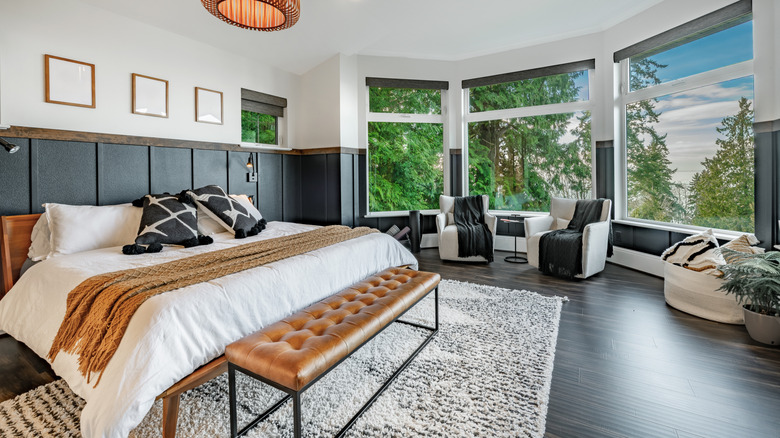A clean, uncluttered bedroom with a large bed and chairs.