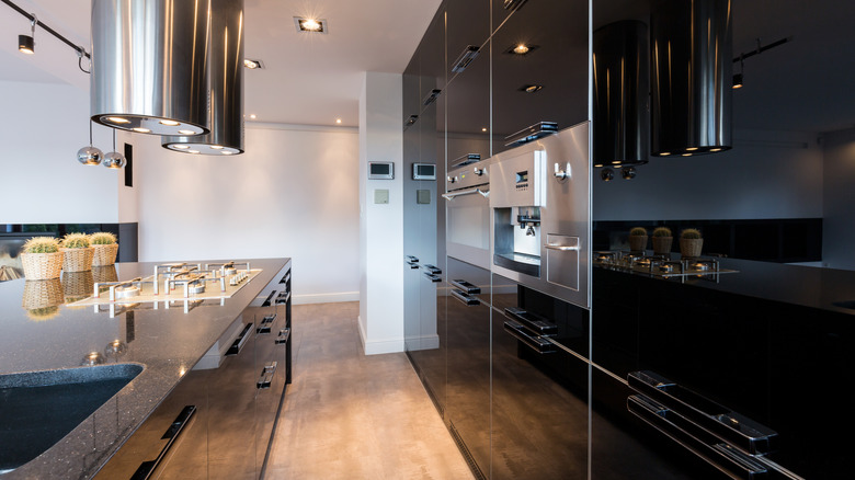 A kitchen with black cabinets with a glossy finish