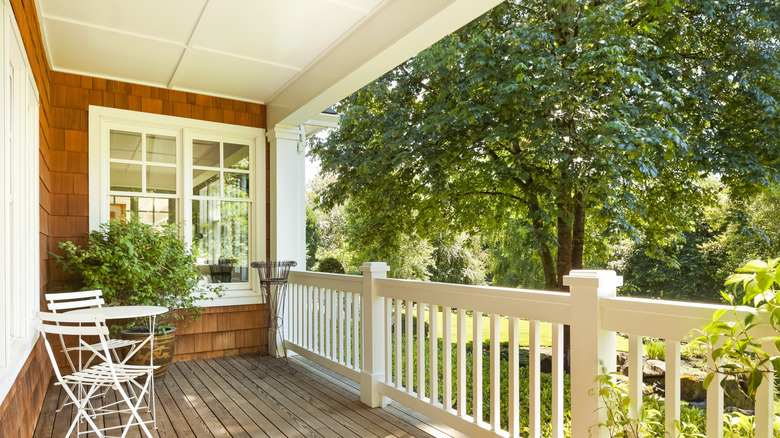 Covered front porch with lots of shade and one big plant.