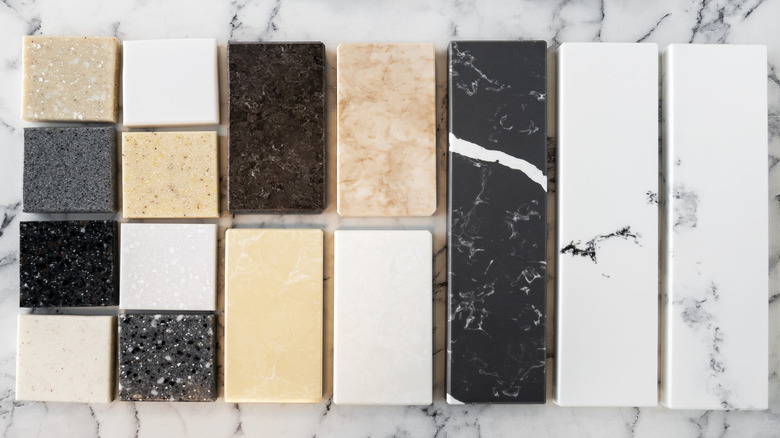 A variety of kitchen countertop material samples are stacked next to each other
