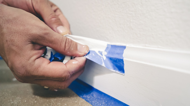 pulling painter's tape off baseboard