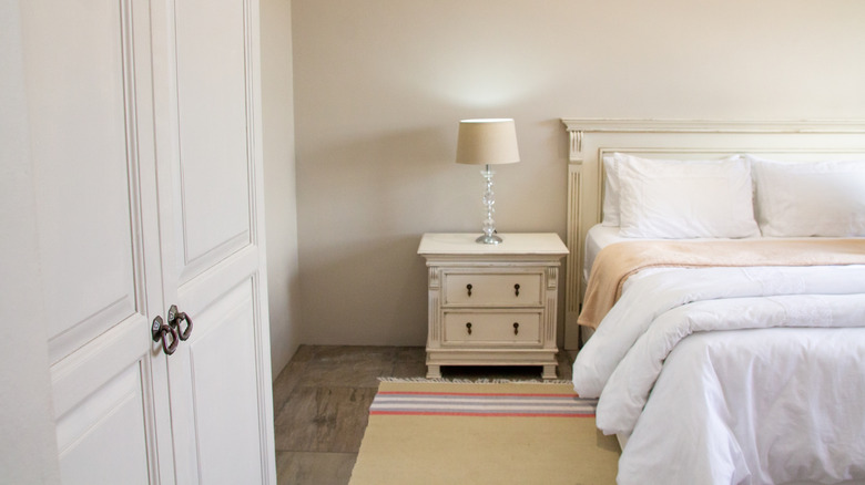 Vintage white bedside table with lamp