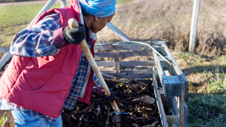 Woman turns compost.