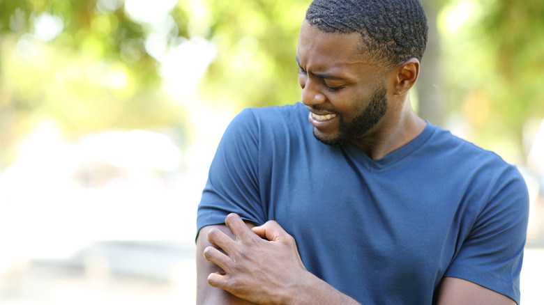 A man scratching a bug bite