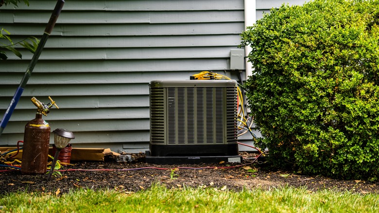 Outdoor HVAC unit next to a bush