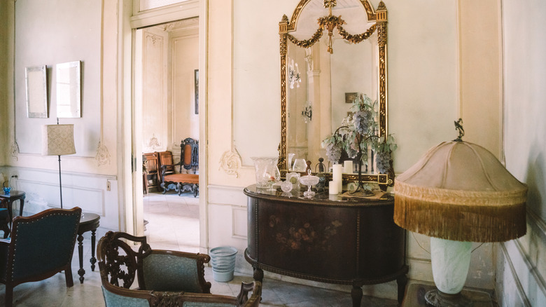 Old-fashioned home furnishings and decor with fringed lampshade