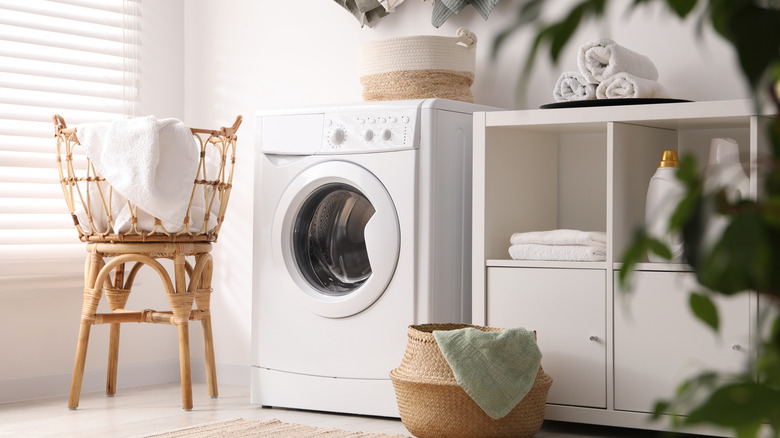 Washing machine surrounded by baskets and shelving