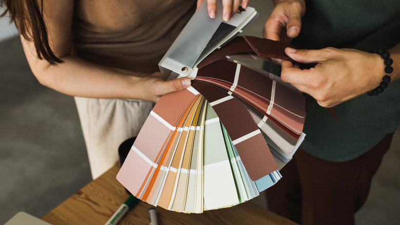 Above view of two people looking through paint swatches