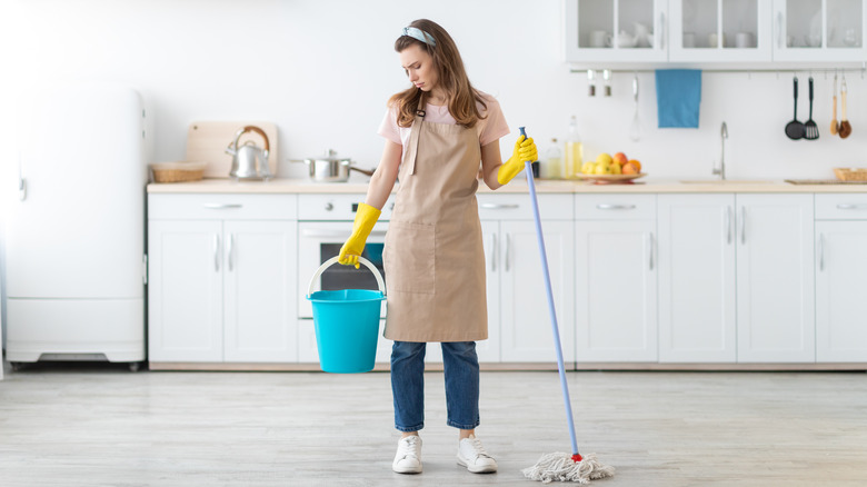 woman holding mop and bucket