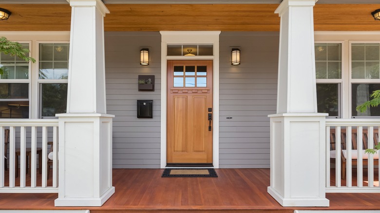Wooden front door underneath a porch
