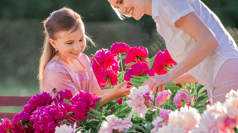 Woman and girl in peony garden