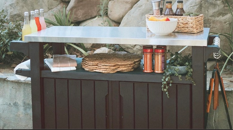 A Keter portable kitchen island outside