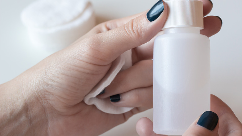 Hands holding acetone bottle