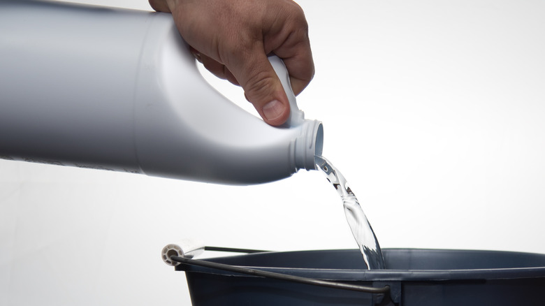 person pouring bleach 