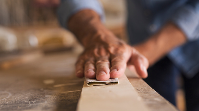 man sanding wood