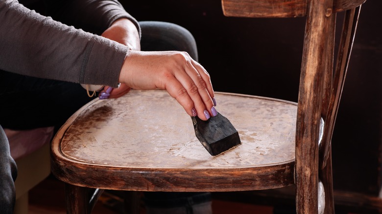 Woman's hand spackling chair seat