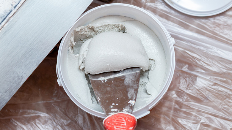 Putty knife inside spackle container