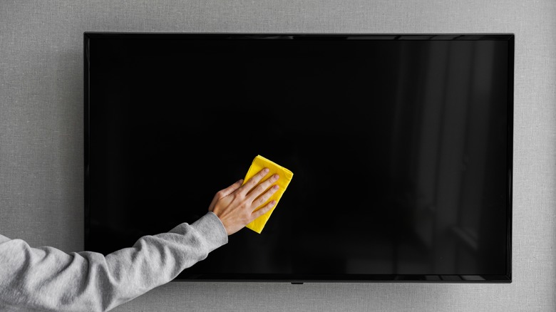 Person cleaning TV screen