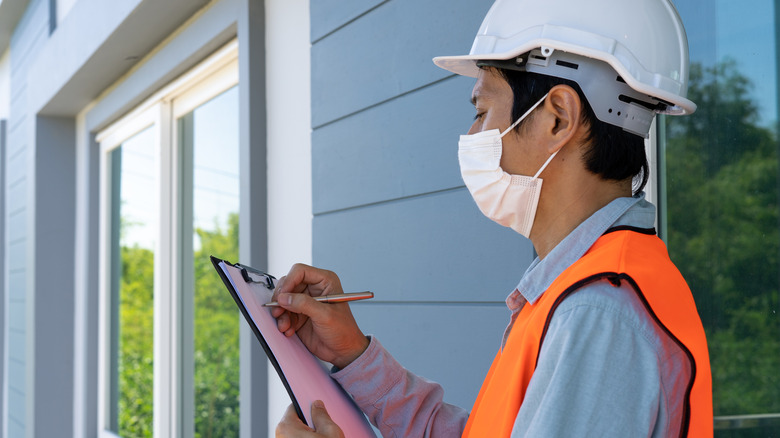 Masked inspector writing on clipboard