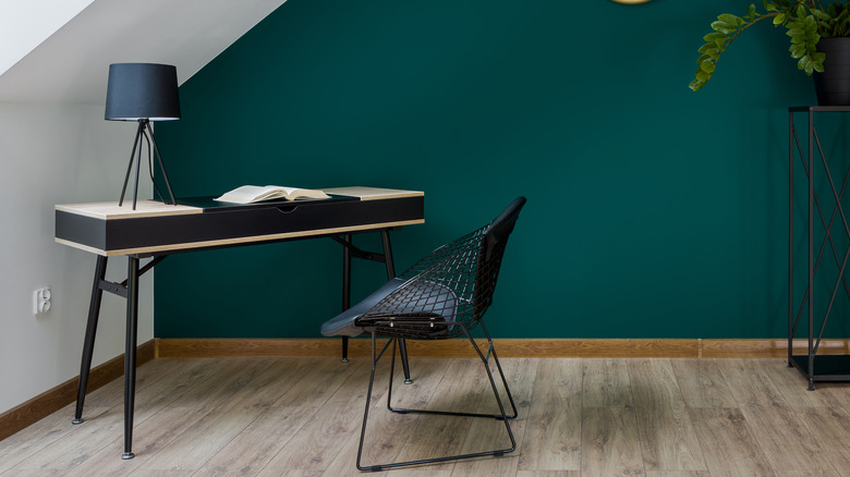 Black desk against green wall