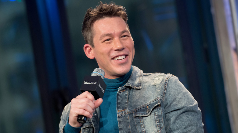 David Bromstad smiling and holding a microphone.
