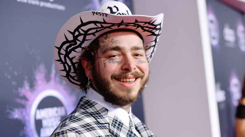 Post Malone smiling for the picture at an event