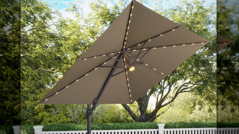 Large Costco patio umbrella with LED lights and square shade coverage in a backyard