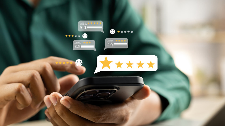 Hands on a phone with 5 star icons floating in the air