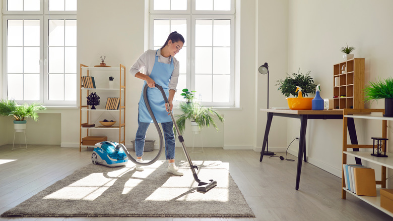 person using carpet cleaner on dirty rug