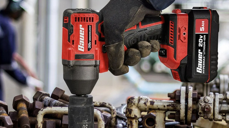 A person using a Bauer impact wrench to tighten a bolt