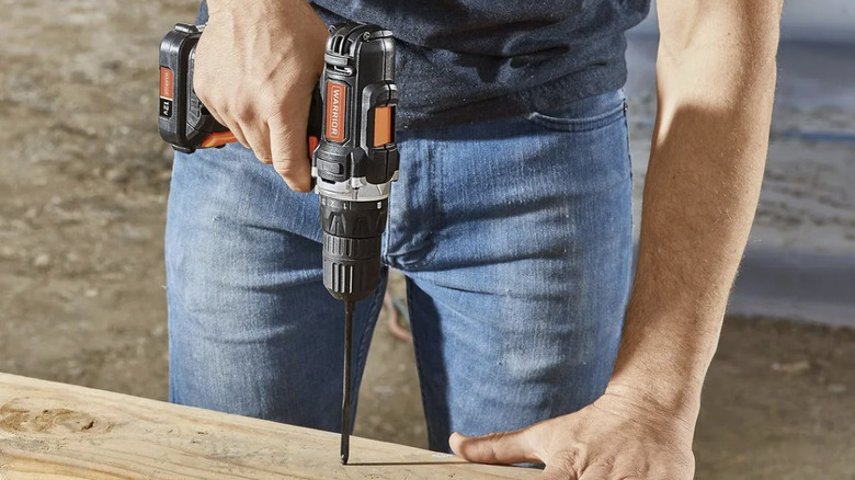 A person using a drill on wood