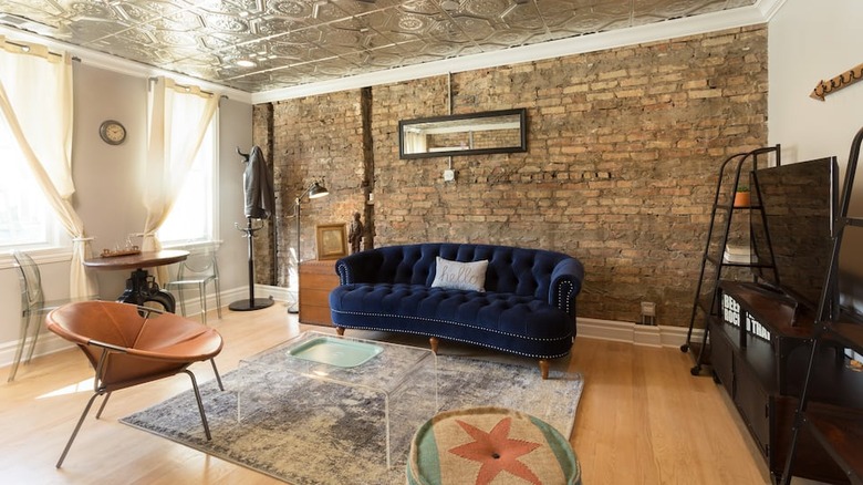 deep blue couch brick wall