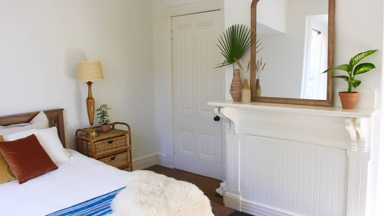 bedroom with white fireplace and mirror