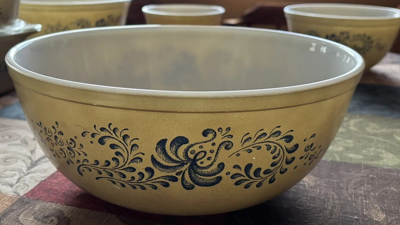A 'Homestead' Pyrex mixing bowl, pale beige with blue swirls.